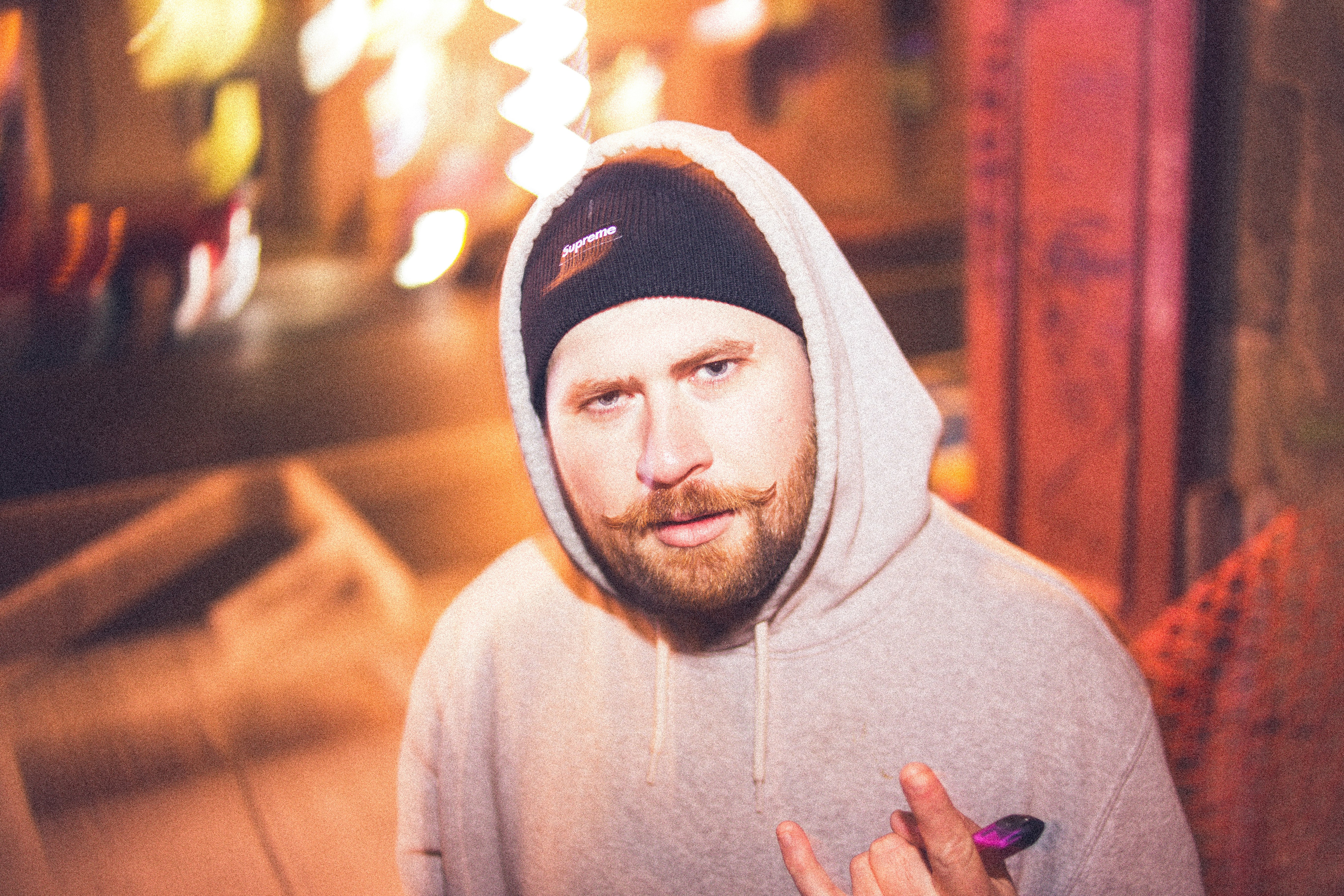 man in gray hoodie wearing black and white knit cap